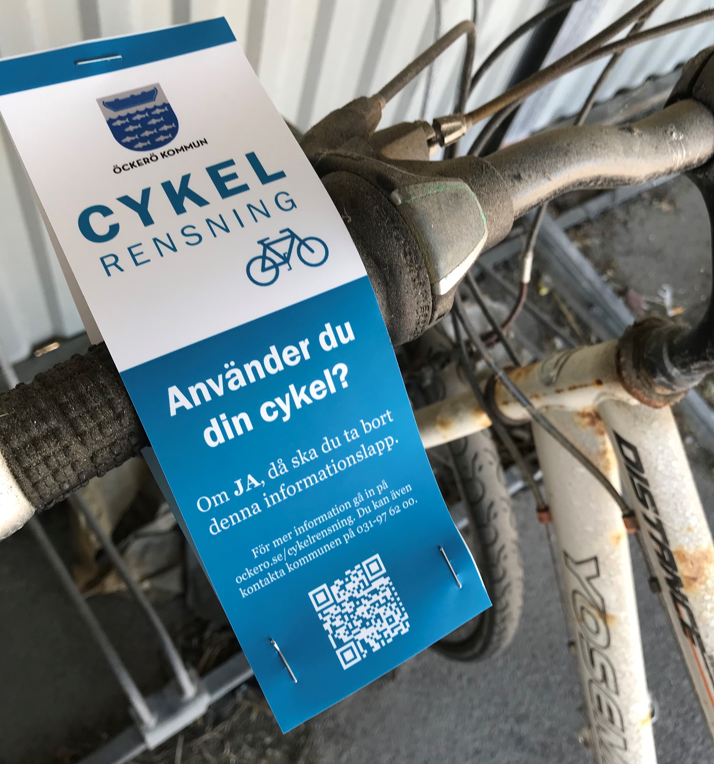 Ett cykelstyre med ett fastsatt pappermed information från Öckerö kommun om cykelrensningen.