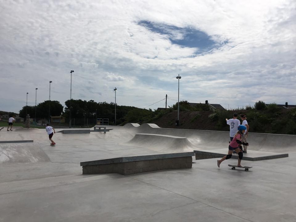 Barn som åker skateboard i skatepark